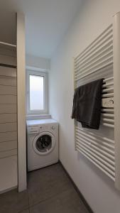 een wasruimte met een wasmachine en een raam bij FEWO VRONI - Wohlfühlambiente mit Stil und Terasse in Rattelsdorf