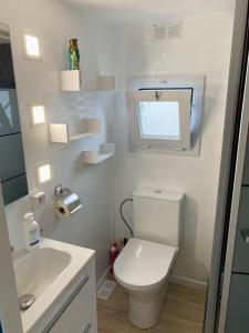 a white bathroom with a toilet and a sink at Chalet D'Mar in Wenduine +24 photos