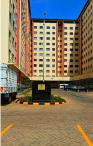 un edificio con un letrero en medio de un estacionamiento en Lin PrimeStay Suites Kisumu, en Kisumu