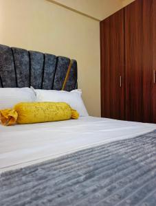 Una cama con una manta amarilla encima. en Lin PrimeStay Suites Kisumu, en Kisumu 17 fotos más