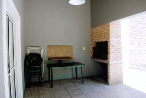 a room with a table next to a brick fireplace at Termas Concepcion in Concepción del Uruguay