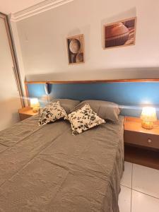 a bedroom with a bed with two pillows on it at Flat Completo Natal Praia do Meio in Natal +8 photos