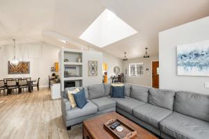 Una sala de estar con un sofá gris y una mesa. en Forest Heights Mountain Views Hot Tub Heated Floors Pizza Oven, en Flagstaff