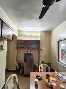 a kitchen with a table and a refrigerator at Veenus Residency - Chinchwad in Chinchwad