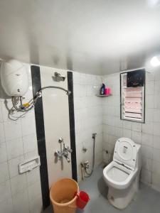 a small bathroom with a toilet and a shower at Veenus Residency - Chinchwad in Chinchwad