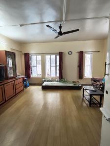 a living room with a couch and a ceiling fan at Veenus Residency - Chinchwad in Chinchwad