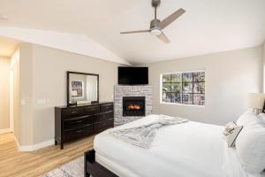 Un dormitorio con una cama y una chimenea. en Forest Heights Mountain Views Hot Tub Heated Floors Pizza Oven, en Flagstaff