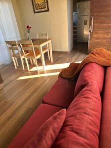 a living room with a red couch and a table at El Vesuvio in San Clemente del Tuyú