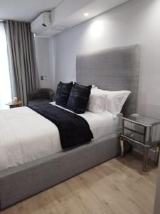 ミッドラントにあるEllipse Lux Hotel - Apartmentのベッドルーム1室(大型ベッド1台、サイドテーブル付)