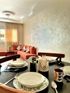 a living room with a table with plates on it at Appartement agadir centre in Agadir +59 photos