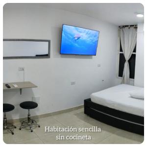 a bedroom with a bed and a tv on the wall at apartaestudios luna azul rodadero in Gaira