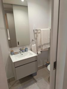 ミッドラントにあるEllipse Lux Hotel - Apartmentの洗面台、鏡、トイレ付きのバスルーム