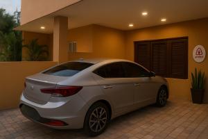 een witte auto geparkeerd voor een huis bij Relaxing and Serene Guest Room in Cancino +1 foto