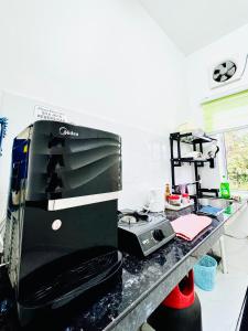 a kitchen counter with a coffee maker and a microwave at AL Homestay Pendang in Pendang +7 photos