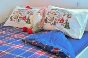 维尔蒂尼克Aria lux apartmani的一张床上放着两个枕头和一个圣诞老人枕头