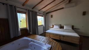 a room with a bed and a bath tub at Pousada Verde Serena SFX in São Francisco Xavier