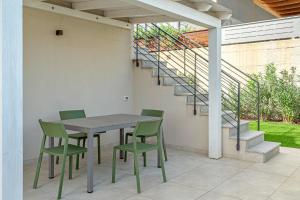 une table et des chaises sur une terrasse avec des escaliers dans l'établissement Villa Luce in Sardegna, à Porto Pozzo