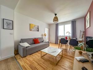 ein Wohnzimmer mit Sofa und Tisch in der Unterkunft L'aube Climatisation Parking 2 chambres in Grenoble