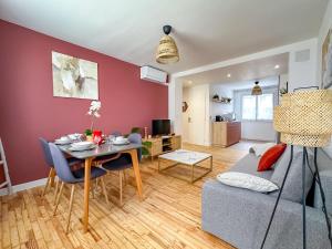 ein Wohnzimmer mit einem Tisch und einem Sofa in der Unterkunft L'aube Climatisation Parking 2 chambres in Grenoble