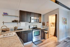 a kitchen with stainless steel appliances and wooden cabinets at Heart of Greensboro Pet-Friendly Gem 3 Mi to Dtwn in Fisher Park