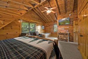 een slaapkamer met een bed in een blokhut bij Mountain Paws #526 in Sevierville +44 foto's