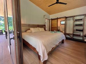 ein Schlafzimmer mit einem Bett und einem Deckenventilator in der Unterkunft Manzanillo Pool House in Manzanillo