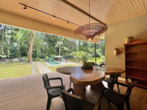 ein Esszimmer mit Tisch und Stühlen und einem großen Fenster in der Unterkunft Manzanillo Pool House in Manzanillo