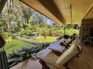 eine Terrasse mit einem Tisch und Stühlen sowie einem Garten in der Unterkunft Manzanillo Pool House in Manzanillo
