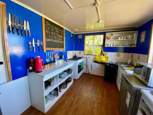 eine Küche mit blauen Wänden und weißer Arbeitsplatte in der Unterkunft Hostel Patagonia Backpackers in Puerto Natales