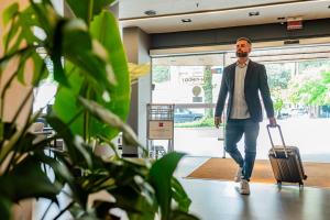 Un hombre con barba que arrastra una maleta en Ibis Florianopolis, en Florianópolis