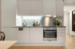 a kitchen with white cabinets and a stove at Modern downtown apartment in Fredrikstad