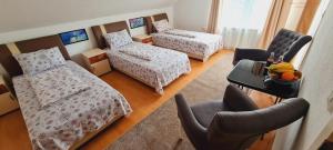 a room with three beds and a table and chairs at VISOKO Room in Visoko