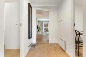 a hallway with white walls and a table and chairs at Modern downtown apartment in Fredrikstad