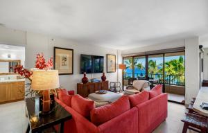 a living room with a red couch and a table at Kaanapali Alii 3 Bedroom Ocean View in Kaanapali