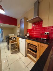 a kitchen with a red brick wall at The Sardinian Guesthouse (6 Bedrooms) in Cobh