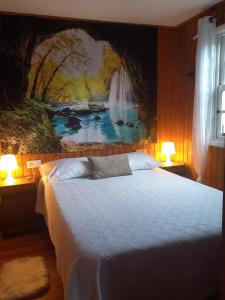 セデイラにあるLa cabañaの壁に絵が飾られたベッドのある寝室