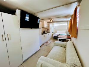 a living room with a couch and a bedroom at White Pearl at Strand in Strand