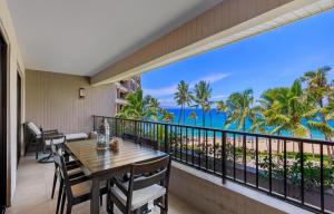 a balcony with a table and chairs and a view of the beach at Kaanapali Alii 3 Bedroom Ocean View in Kaanapali