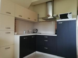 eine Küche mit schwarzen und weißen Schränken und einer Mikrowelle in der Unterkunft Apartament z kogutem in Zakopane