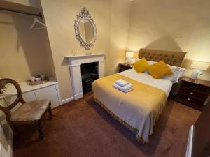 a bedroom with a bed with yellow pillows and a mirror at The Sardinian Guesthouse (6 Bedrooms) in Cobh