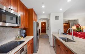 a kitchen with wooden cabinets and stainless steel appliances at Kaanapali Alii 3 Bedroom Ocean View in Kaanapali +76 photos