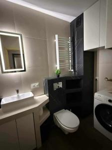 a bathroom with a white toilet and a sink at Apartament Zefir in Busko-Zdrój