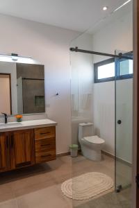 a bathroom with a toilet and a glass shower at The Point At Cerritos # 4 in San Carlos