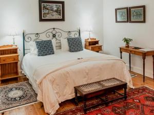 une chambre avec un grand lit avec des oreillers bleus dans l'établissement Cypress Cottage, à Graaff-Reinet