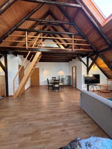 a large living room with a wooden floor and a staircase at Harlekin-Wohnung in Garbsen