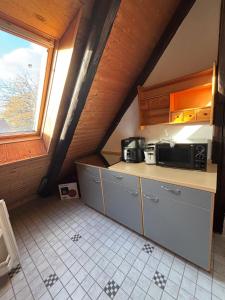 a small kitchen with a counter and a microwave at Harlekin-Wohnung in Garbsen