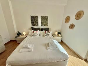 1 dormitorio blanco con 1 cama blanca grande con almohadas en Suite dei Principi 3, aeroporto e parcheggio gratuito, en Bari