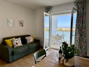 Una sala de estar con un sofá y una mesa con puerta de cristal en Suite dei Principi 3, aeroporto e parcheggio gratuito, en Bari