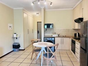 een keuken met een tafel en stoelen erin bij Rockmel Apartment in Sandton