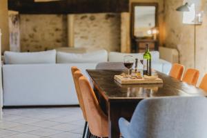a table with a bottle of wine and two glasses at Le Logis de Saint-Chamassy in Saint-Chamassy